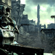A large man wearing a dark grey suit of armor stares at you with a destroy city behind him.